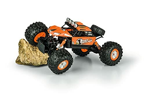 Orange RC-Monstertruck klettert über einen Felsen.